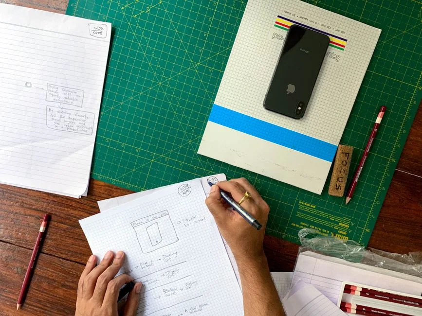 A photographer working at a creative setup with a laptop and Wacom tablet, focused on editing photos indoors.